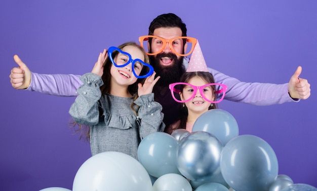 Fiesta de cumpleaños Padre con dos hijas divirtiéndose Concepto de paternidad Familia amistosa usa accesorios divertidos para fiestas Día del padre Las hijas necesitan un padre activamente interesado en la vida Padre soltero