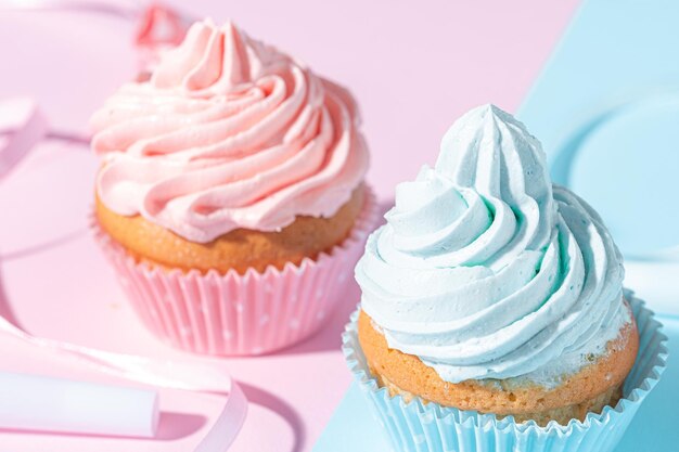 Foto fiesta de género niño o niña dos pastelitos con crema azul y rosa concepto de celebración cuando se conoce el género del niño