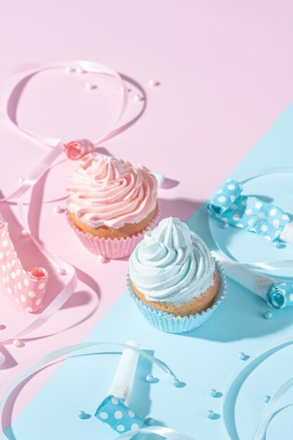 Foto fiesta de género niño o niña dos pastelitos con crema azul y rosa concepto de celebración cuando se conoce el género del niño