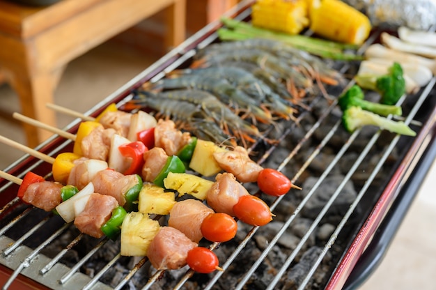 Fiesta Grill y Barbacoa en casa. Cocinar cerdo a la barbacoa, ternera, pollo, mariscos y verduras. Estilo de vida familiar y actividad al aire libre de amigos.