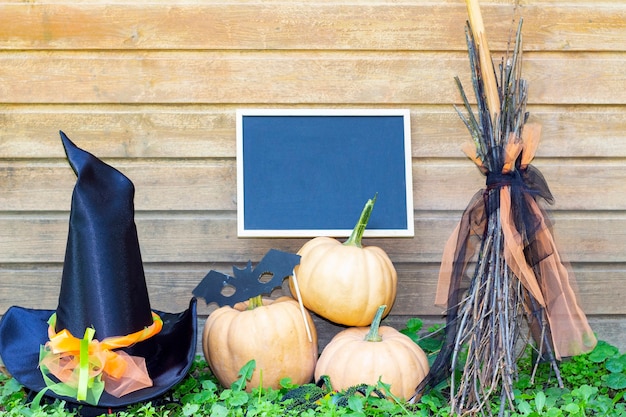 Fiesta de Halloween. Calabazas, sombrero de bruja, escoba de bruja y pizarra