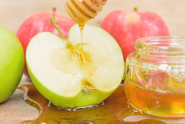 Fiesta judía Apple Rosh Hashaná la foto tiene miel en un tarro y deja caer miel en las manzanas verdes