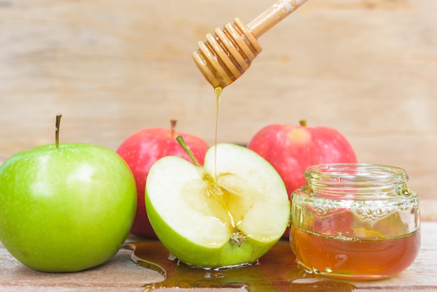 Fiesta judía manzana Rosh Hashaná miel en tarro y gota miel sobre manzanas verdes