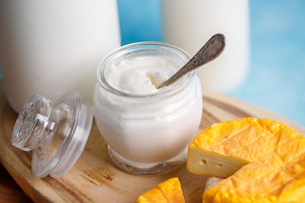 Fiesta judía Shavuot concepto con productos lácteos queso pan botella de leche sobre fondo azul claro