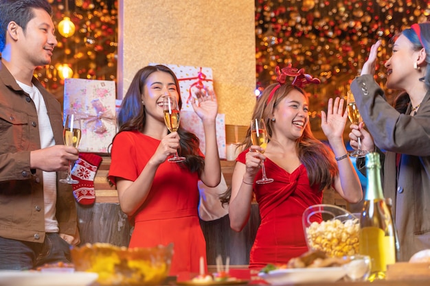 Fiesta de mujeres y hombres asiáticos celebrando la felicidad amigos la víspera de Navidad celebran la cena