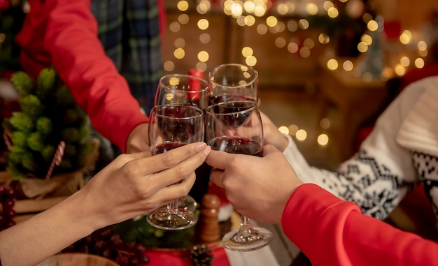 Fiesta de navidad y año nuevo con amigos. Beber vino tinto y champán para la celebración de vacaciones.