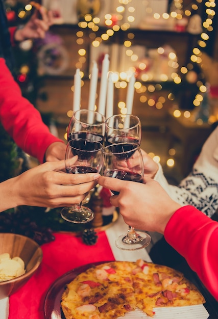 Foto fiesta de navidad y año nuevo con amigos. beber vino tinto y champán para la celebración de vacaciones.