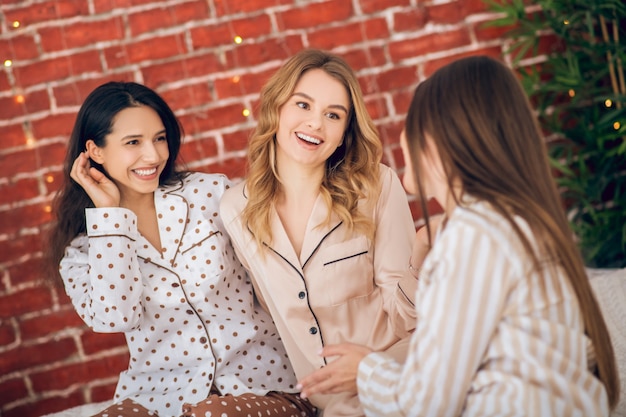 Fiesta de pijamas. Tres chicas guapas en pijama pasando un buen rato juntos