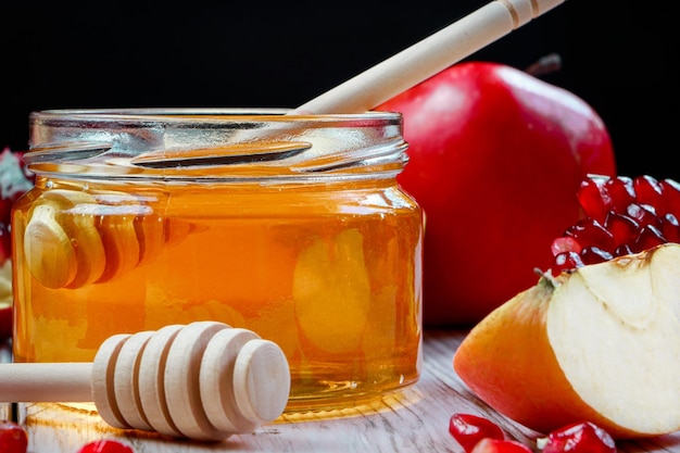 Fiesta religiosa judía tradicional Rosh Hashanah manzanas granadas y miel sobre un fondo de madera oscura