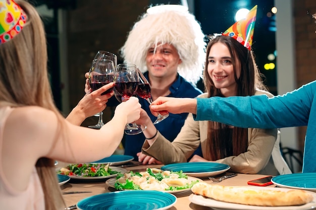 Fiesta en un restaurante. Los amigos se divierten en un restaurante y beben vino. Actitud festiva.