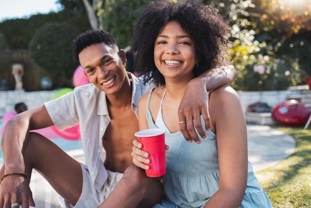 Fiesta de retratos y verano con una pareja negra divirtiéndose al aire libre mientras bebe en un evento de celebración Me encanta el alcohol y el cumpleaños con un hombre y una mujer jóvenes afuera juntos en una reunión social