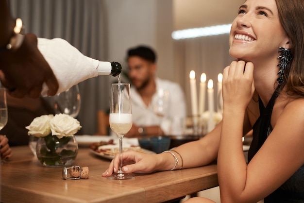 Fiesta sirviendo champán y mujer en una cena con amigos para celebrar la víspera de Año Nuevo Amistad sirviendo vino espumoso o alcohol en una cena elegante mientras celebra