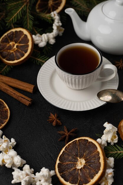 Fiesta de té navideña con árbol de navidad, naranjas secas y guirnalda de palomitas de maíz