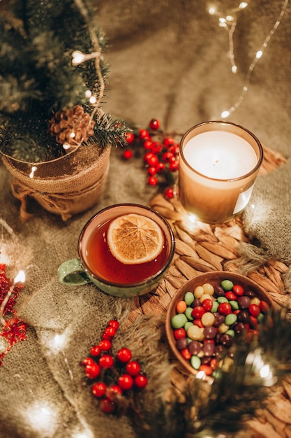 Fiesta del té por la noche con luces de Navidad, té caliente y dulces.