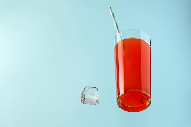 Fiesta de verano cóctel rojo en un vaso con una pipa y hielo