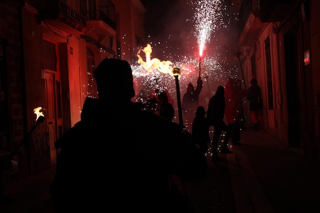 Foto fiestas de correfoc típicas con petardos y luces en las ciudades