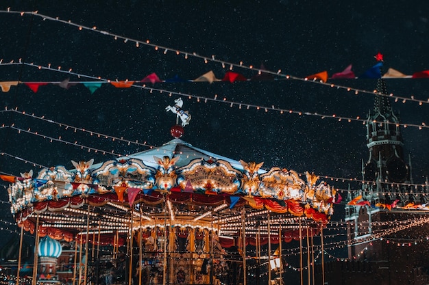 Fiestas mágicas en Moscú festivos niños alegres giran alrededor de carrusel diversión en el ambiente de año nuevo