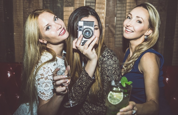 Fiesteras en un restaurante celebrando con bebidas y champaña