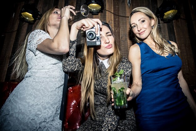 Fiesteras en un restaurante celebrando con bebidas y champaña