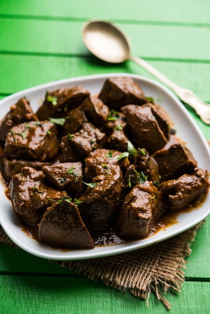 Foto fígado de carneiro frito ou kaleji masala, receita popular não vegetariana da índia e do paquistão. servido seco ou com curry em uma tigela, karahi ou prato