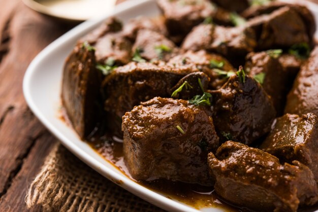 Fígado de carneiro frito ou kaleji masala, receita popular não vegetariana da índia e do paquistão. servido seco ou com curry em uma tigela, karahi ou prato