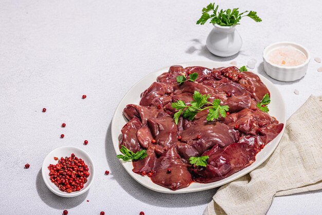 Fígado de frango cru em fundo de pedra Ingredientes frescos prontos para cozinhar salsa pimenta vermelha Tendência dura luz escura sombra plana leiga espaço de cópia