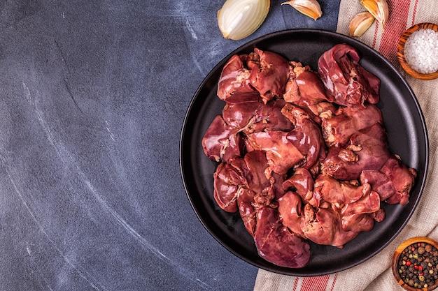 Fígado de frango cru em um prato preto