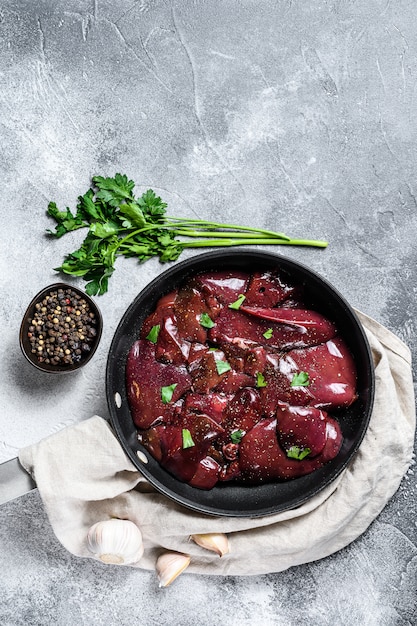 Fígado de frango cru em uma frigideira. Vista do topo.