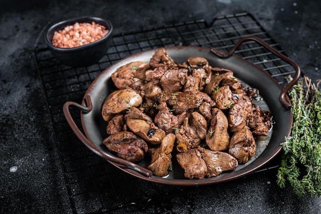 Fígado de frango frito com cebola e ervas Fundo preto Vista superior