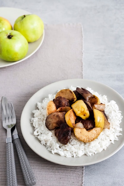 Fígado de frango frito com maçãs servido com arroz branco no prato