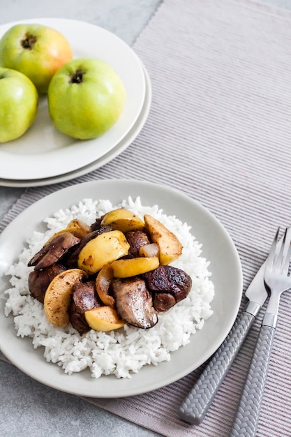 Fígado de frango frito com maçãs servido com arroz branco no prato