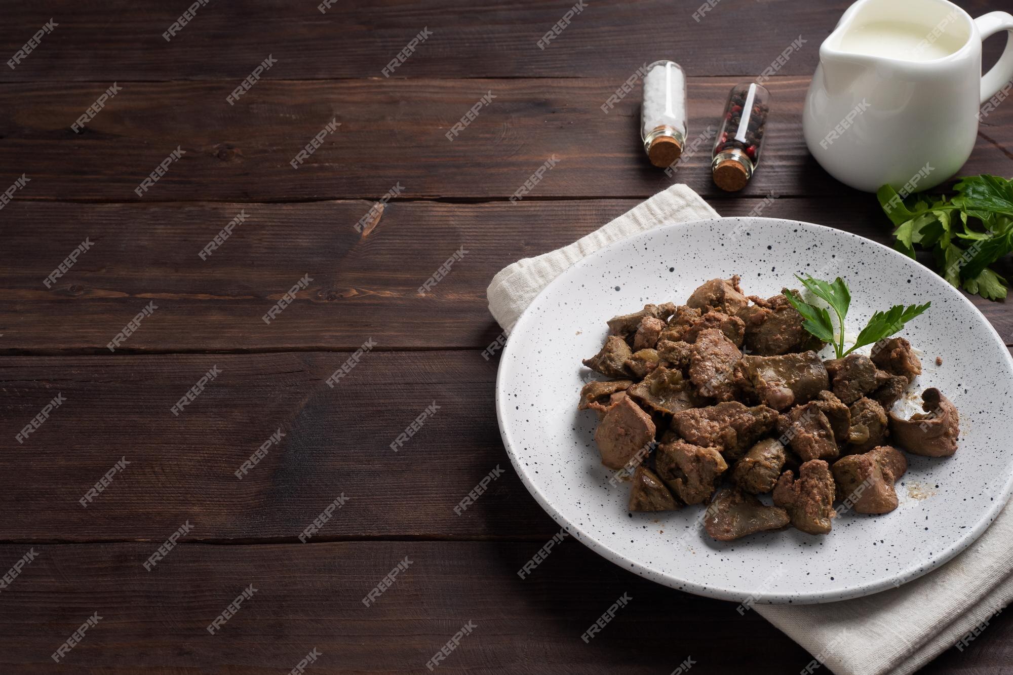 fígado de frango frito ou assado com cebola e molho, folhas de salsa verde  em um prato. prato de carne enriquecido com ferro. espaço de cópia 8957857  Foto de stock no Vecteezy