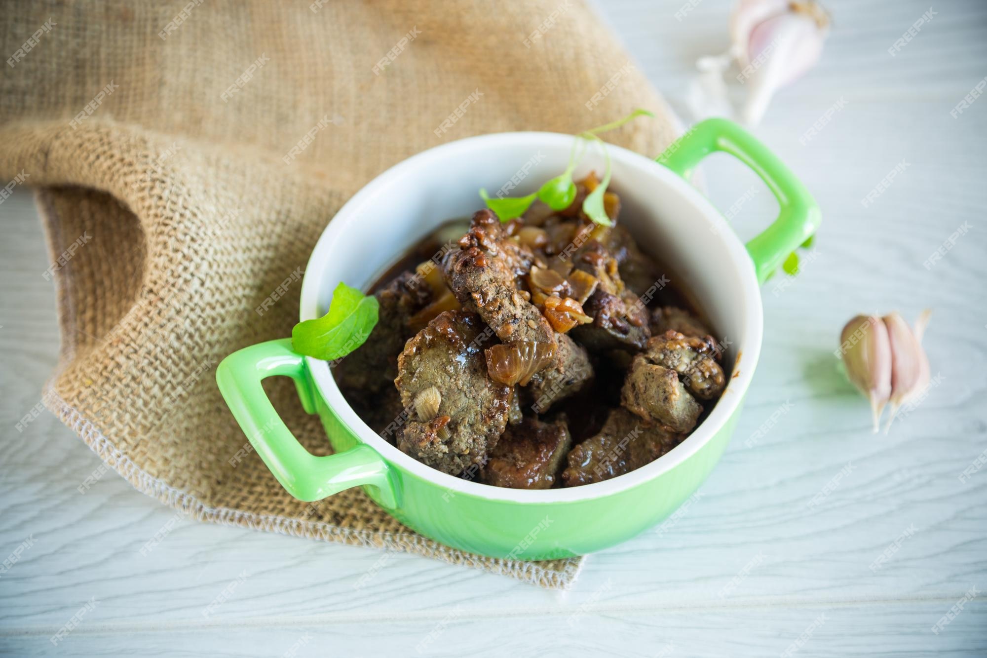 Fígado frito com cebola e especiarias num prato sobre a mesa