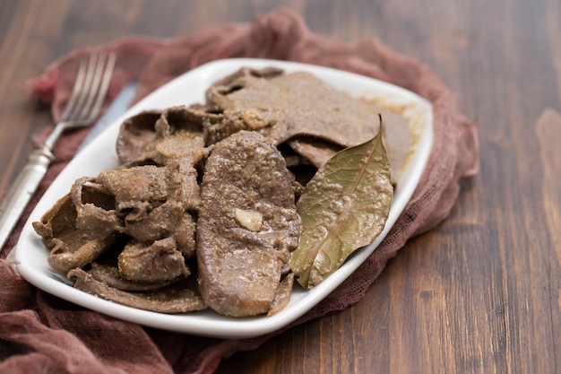 Fígado frito com cebola e especiarias num prato sobre a mesa