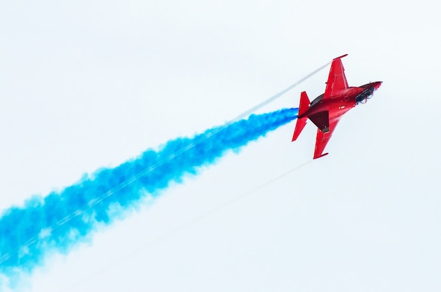 Fighter voa na fumaça no céu azul acrobacias