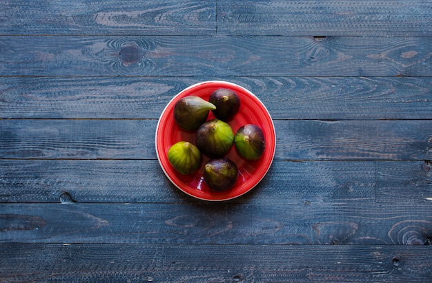 Figos frescos com pêssegos, damascos, mirtilos, morangos, sobre uma mesa de madeira