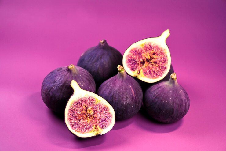 Foto figos inteiros e cortados em um fundo roxo cozinha mediterrânea
