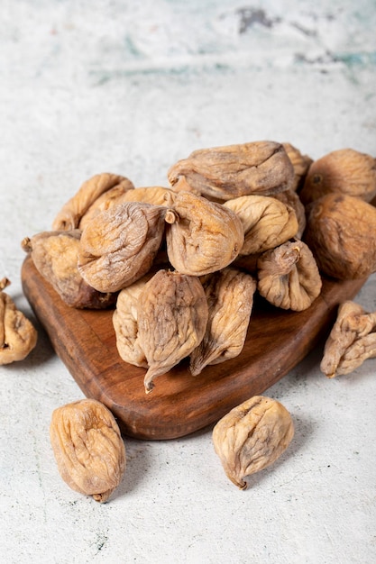 Figos secos em fundo de pedra Figos secados no sol em uma tábua de madeira Alimentos dietéticos de perto