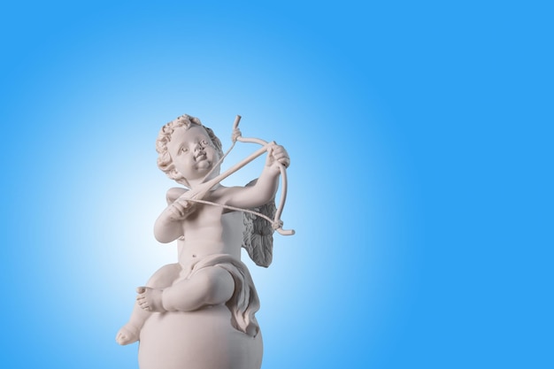 Figur eines Engels Cupid auf dem Podium mit Pfeil und Bogen auf einem blauen Hintergrund ValentinstagPlatz für Text