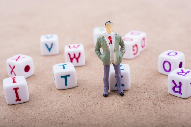 Foto figur steht vor den bunten buchstabenwürfeln