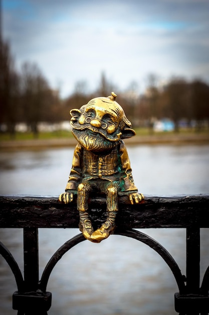 Figura de bronce del abuelo sentado en el puente