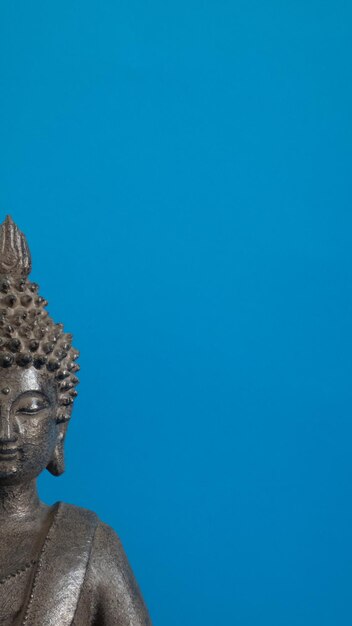 Figura Buda cinza em fundo azul