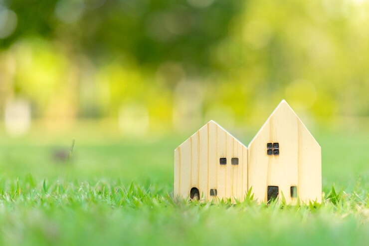 Figura de casa en el prado con hierba en fondo verde natural cerrado pequeño modelo de casa en hierba verde en el parque inversión de negocios y concepto de bienes raíces nuevo concepto de casa y casa