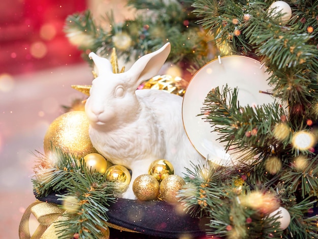 Figura de un conejo de cerámica con globos debajo del árbol Un símbolo del próximo año 2023