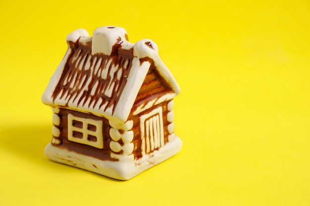 Figura de casa em fundo amarelo, compra, hipoteca de habitação ou um apartamento.