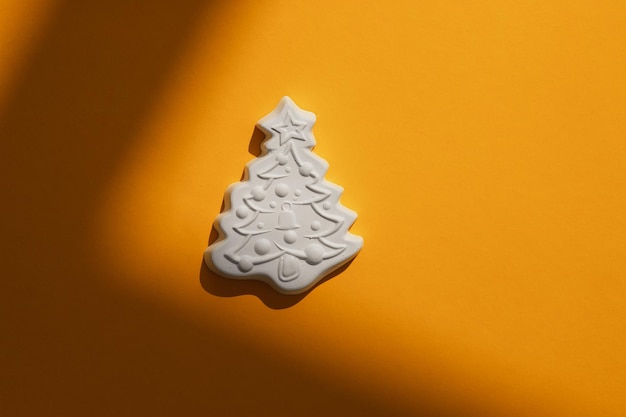 Figura de gesso de uma árvore de Natal em um fundo colorido