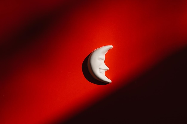 Figura de gesso de uma lua em um fundo vermelho