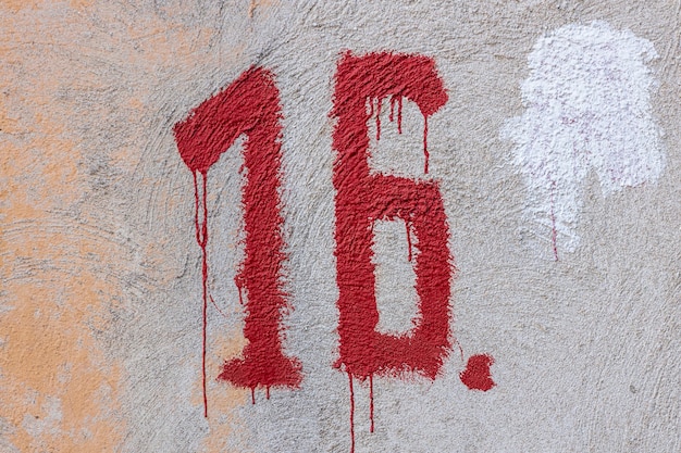 Figura dezesseis tinta vermelha com sedts na parede de pedra da casa. hematoma. Foto de alta qualidade