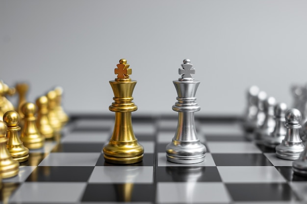 Figura do rei do xadrez de ouro e energia ou oponente do xeque-mate durante a competição do tabuleiro de xadrez.