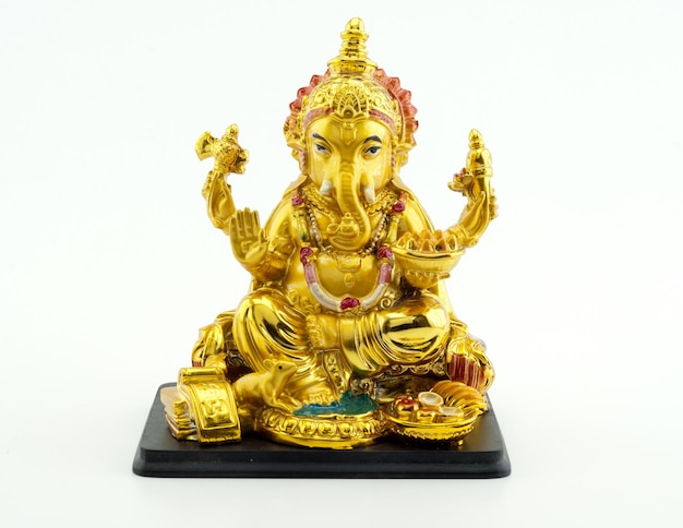 Figura dorada del elefante Ganesha sobre fondo blanco.